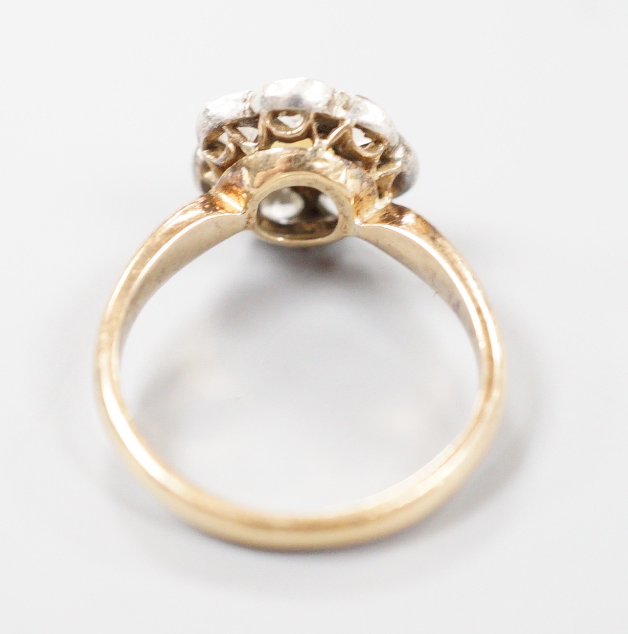 A late Victorian yellow metal, single stone split pearl and seven stone diamond set circular cluster ring, size I, gross weight 3 grams.